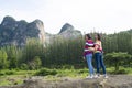 Two young girl have fun at beautiful landscape view of mountain and pine tree Royalty Free Stock Photo