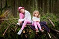 Two young girl playing and having fun together on walk in forest outdoors. Happy loving family with two sisters or female friends Royalty Free Stock Photo