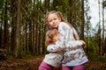 Two young girl playing and having fun together on walk in forest outdoors. Happy loving family with two sisters or female friends Royalty Free Stock Photo