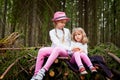 Two young girl playing and having fun together on walk in forest outdoors. Happy loving family with two sisters or female friends Royalty Free Stock Photo