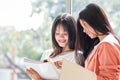 Two Young girls Asian College groups of students using tablet, laptop to studying together with documents paper for report in Royalty Free Stock Photo