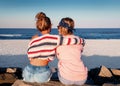 Two young girls, best friends sitting together on the beach at s Royalty Free Stock Photo
