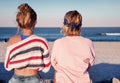 Two young girls, best friends sitting together on the beach at s Royalty Free Stock Photo