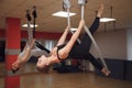 Two young girls do fly yoga and stretches in the studio