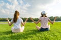 Two young girls doing yoga pose outdoor, yoga at sunset in the park, back view. Royalty Free Stock Photo