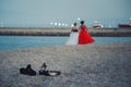 Two young girls in fashionable dresses walking at sandy beach without shoes evening time. Teens together outside at the beach