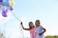 Two Young Girls Holding Bunch Of Colorful Balloons Outdoors Royalty Free Stock Photo