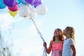 Two Young Girls Holding Bunch Of Colorful Balloons Outdoors Royalty Free Stock Photo