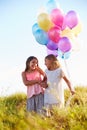 Two Young Girls Holding Bunch Of Colorful Balloons Outdoors Royalty Free Stock Photo