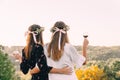 Two young girls hug during sunset in the field with wine glasses friendship concept copy space Royalty Free Stock Photo