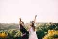 Two young girls hug during sunset in the field with wine glasses friendship concept copy space Royalty Free Stock Photo