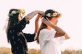 Two young girls hug during sunset in the field with wine glasses friendship concept copy space Royalty Free Stock Photo