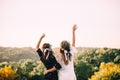 Two young girls hug during sunset in the field with wine glasses friendship concept copy space Royalty Free Stock Photo