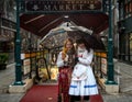 Two young girls with hungarian traditional national clothes in front of touristic goods market. Budapest, Hungary