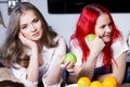 Two young girls in the kitchen talking and eating Royalty Free Stock Photo