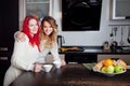 Two young girls in the kitchen talking and eating Royalty Free Stock Photo