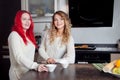 Two young girls in the kitchen talking and eating Royalty Free Stock Photo