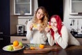 Two young girls in the kitchen talking and eating Royalty Free Stock Photo