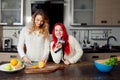 Two young girls in the kitchen talking and eating Royalty Free Stock Photo