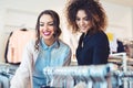 Two young girls look at clothing in store