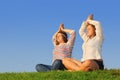 Two young girls meditate at green grass