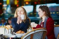 Two young girls in Parisian outdoor cafe Royalty Free Stock Photo