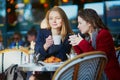 Two young girls in Parisian outdoor cafe Royalty Free Stock Photo