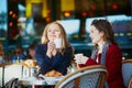 Two young girls in Parisian outdoor cafe Royalty Free Stock Photo