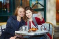 Two young girls in Parisian outdoor cafe Royalty Free Stock Photo