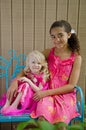 Two young girls in pink on blue bench