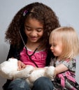 Two young girls playing doctor