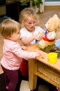 Two young girls playing with educative bear toy