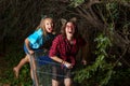 Two Young Girls Playing in a Shopping Cart Under an Overgrown Me