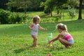 Two young girls playing with toy sprinkler Royalty Free Stock Photo