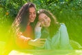 Two women with smartphone  sit in outdoor cafe, sharing the news and  laughing, girls party concept Royalty Free Stock Photo