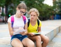 Two young girls sitting in park and doing homework Royalty Free Stock Photo