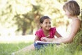 Two Young Girls Sketching In Countryside Leaning Against Tree Royalty Free Stock Photo