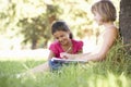 Two Young Girls Sketching In Countryside Leaning Against Tree Royalty Free Stock Photo