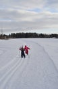 Two young girls skiing and walking in winter wonderland. Flat skiing is a good activity for kids on vacation Royalty Free Stock Photo