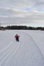 Two young girls skiing and walking in winter wonderland. Flat skiing is a good activity for kids on vacation Royalty Free Stock Photo