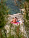 Two young girls sunbathing on rocks by the sea Royalty Free Stock Photo