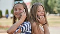 Two young girls talking on the phone on a summer day. Royalty Free Stock Photo