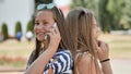 Two young girls talking on the phone on a summer day. Royalty Free Stock Photo