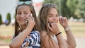 Two young girls talking on the phone on a summer day. Royalty Free Stock Photo