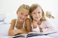 Two Young Girls In Their Pajamas, Reading A Book Royalty Free Stock Photo