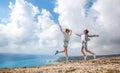 Two young girls traveler jumping against a stunning beautiful la Royalty Free Stock Photo