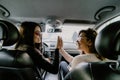 Two young beautiful girls traveling by car giving five palms facing each other despite the road Royalty Free Stock Photo