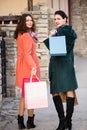 Two young girls walk down the street while shopping