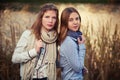 Two young fashion girls in white shirt and scarf walking outdoor Royalty Free Stock Photo