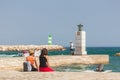 Two young girls watching the waves at the pier / harbour entrance, Lagos, Portugal